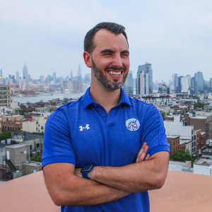 Daniel O Connor photographed wearing a blue sports jersey in front of a city skyline.