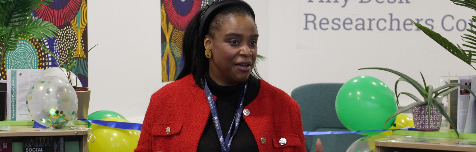 Woman wearing red jacket, delivering a speech