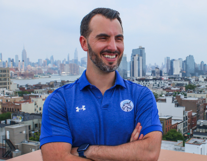 Daniel O Connor photographed wearing a blue sports jersey in front of a city skyline.