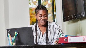 Student living in university accommodation working on a laptop