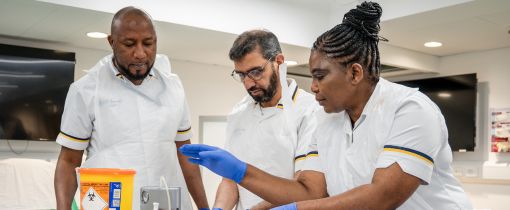 Students with blue gloves on and injection in hands. 3 students, 2 males and 1 female