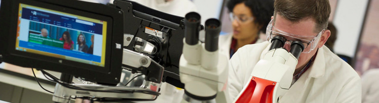 A student wearing headphones looking at a laptop screen