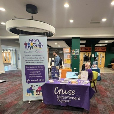 Cruse Bereavement male representative sitting at a talk stable during the neurodiversity event