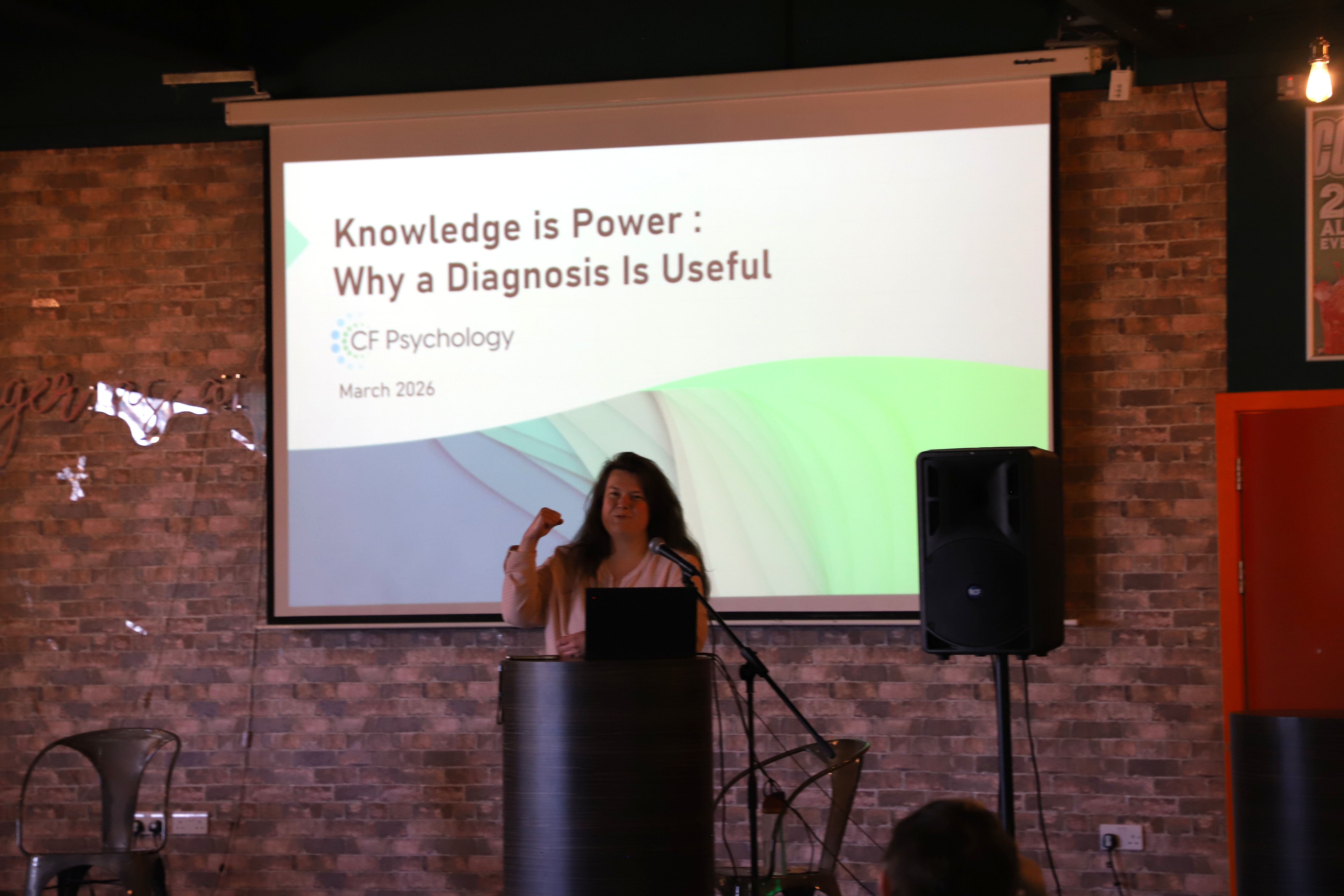 a lady with brown hair presenting a talk on stage